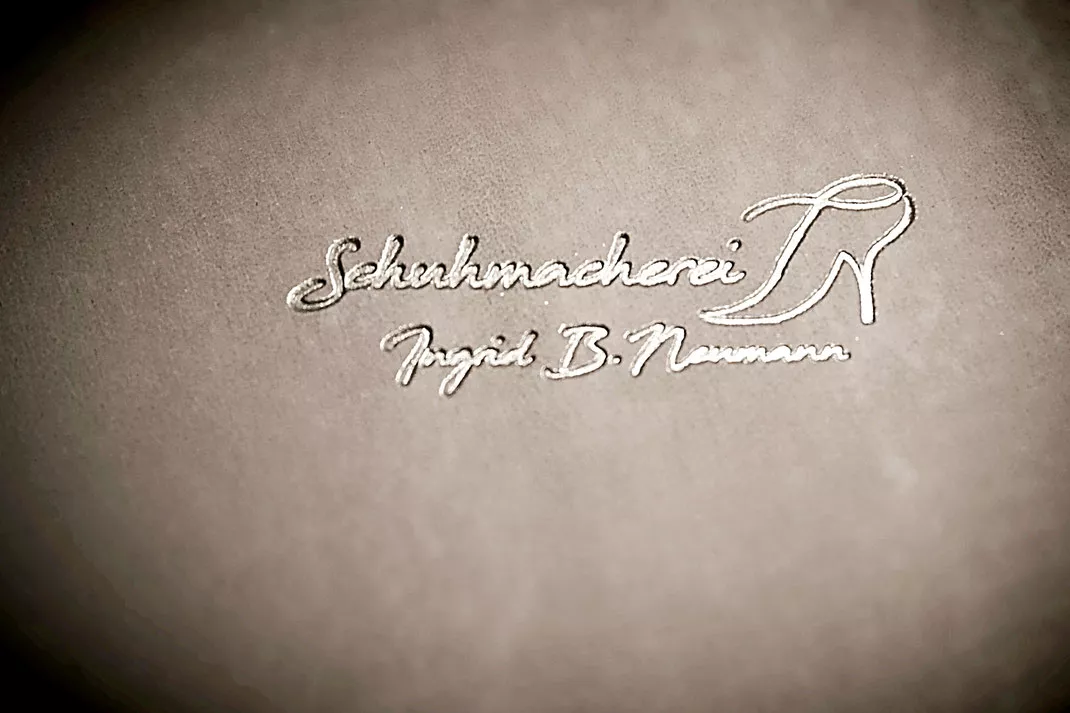 Schuhmacherei Logo auf Kalbsleder grau